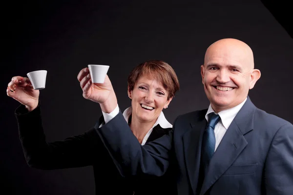 Um casal de idosos segurando duas xícaras de café espreso — Fotografia de Stock