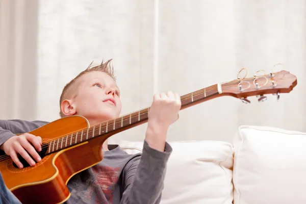 Liten pojke spelar gitarr hemma — Stockfoto