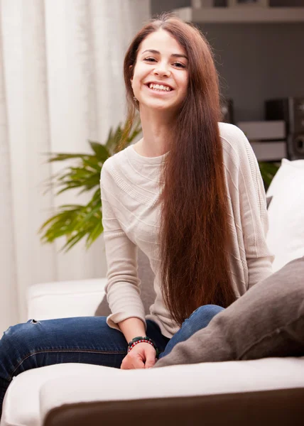 Menina sorridente feliz em um sofá — Fotografia de Stock