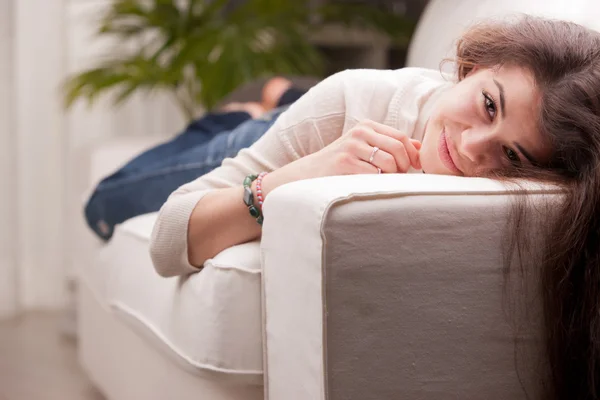 Mooie jonge meisje te wachten en lacht op een sofa — Stockfoto