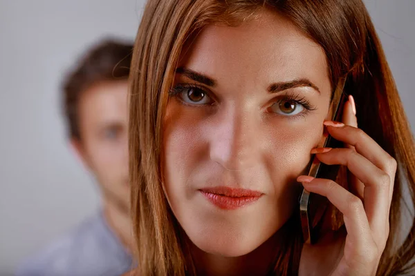 Junge Frau Telefoniert Während Hinter Ihr Ein Halb Versteckter Mann — Stockfoto