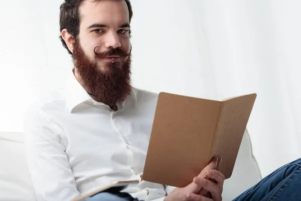 Man Beard Showy Moustaches Reading Paper Notebook His Sofa Waiting — Stock Photo, Image