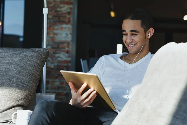 Junger Mann Lacht Während Mit Kopfhörern Ein Lustiges Video Oder — Stockfoto