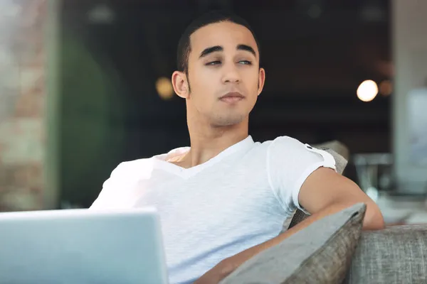 Mladý Muž Zamyšleně Dívá Stranou Odpočívá Pohovce Pracuje Notebooku — Stock fotografie