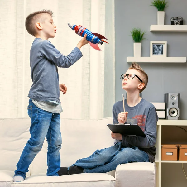 Netter Kleiner Junge Spielt Mit Einer Spielzeugrakete Auf Einem Sofa — Stockfoto