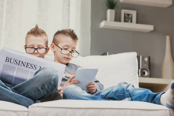 Dois Meninos Vestindo Óculos Relaxando Sofá Lendo Notícias Negócios Book — Fotografia de Stock