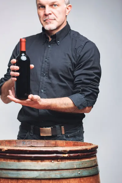 Homem Sênior Exibindo Uma Garrafa Vinho Tinto Sem Rótulo Suas — Fotografia de Stock