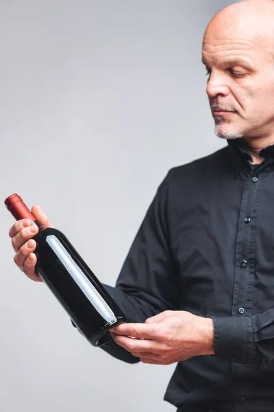 Thoughtful Senior Man Eyeing Unlabelled Bottle Red Wine Held His — Stock Photo, Image