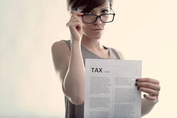 Stern Młoda Kobieta Trzyma Formularz Podatkowy Ręku Jak Patrzy Przez — Zdjęcie stockowe