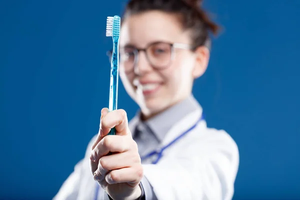 Planda Odaklanmış Diş Fırçası Arka Planda Odak Dışı Bir Dişçi — Stok fotoğraf