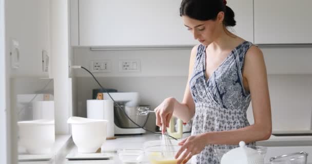 Slender woman cooking in a white kitchen — Stock Video