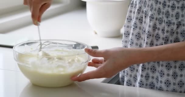 Beyaz bir mutfakta ince bir kadın yemek pişiriyor. — Stok video