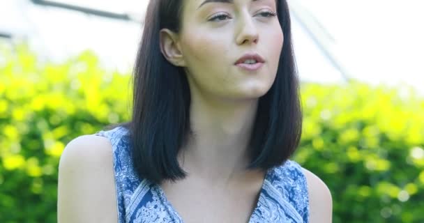 Jonge blanke vrouw in een tuin zat en mooi — Stockvideo