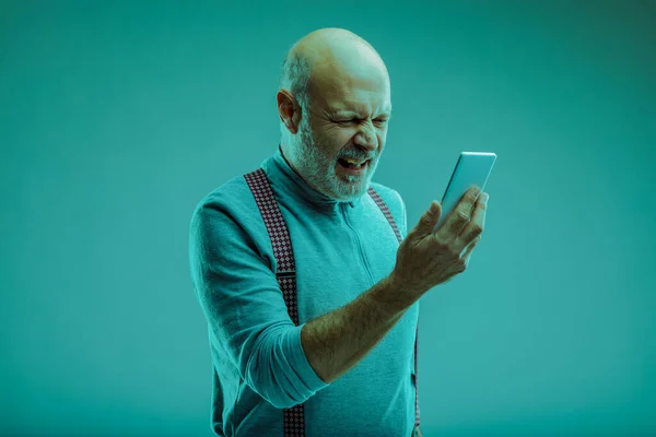 Senior Man Grimacing Looking His Smartphone Disgust Hokds Front Him — Stock Photo, Image