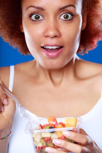 若いです黒女性Gawpingでカメラで驚きで見つめます目と口を開けます彼女は果物サラダのボウルを保持しています — ストック写真