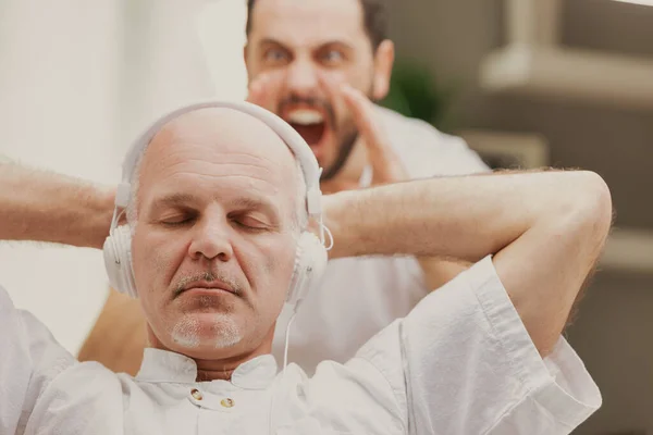 Filho Gritando Com Seu Pai Que Está Ouvindo Música Fones — Fotografia de Stock