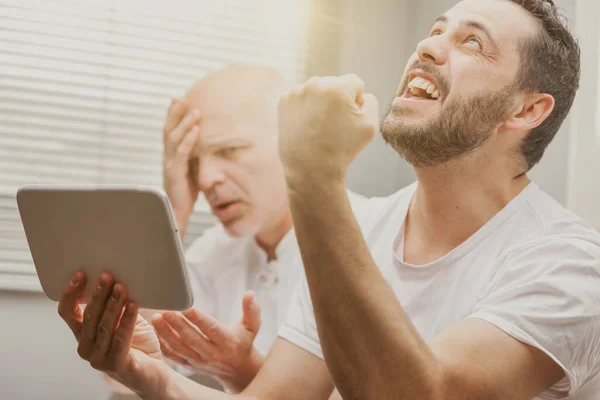 Een Man Kijkt Naar Zijn Handheld Tablet Toont Ontzetting Terwijl — Stockfoto