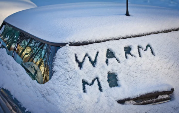 Warm me written in snow on car windscreen below windscreen wiper — Stock Photo, Image