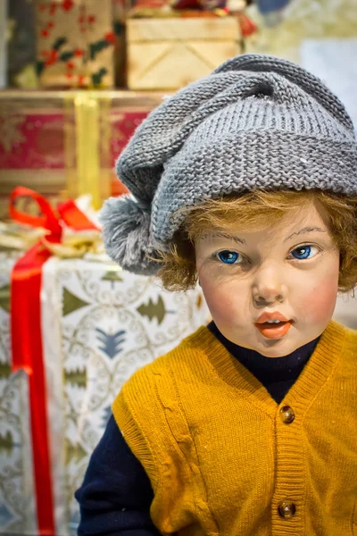 Weihnachtspuppe Junge gegen Geschenk-Boxen Hintergrund. Retro-Stil — Stockfoto