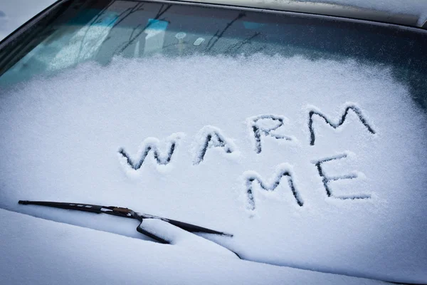 Réchauffez-moi écrit dans la neige sur le pare-brise de voiture sous l'essuie-glace — Photo