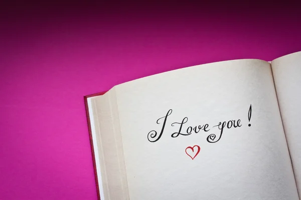 Me encantan las palabras en el libro abierto con fondo rosa y copiar el espacio para su texto. Concepto de declaración de amor. También es bueno para la postal . — Foto de Stock