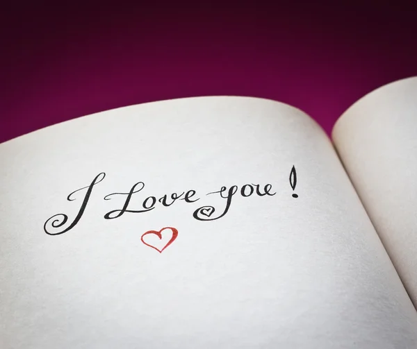 Me encantan las palabras en el libro abierto con fondo rosa. Concepto de declaración de amor.También es bueno para la postal . — Foto de Stock