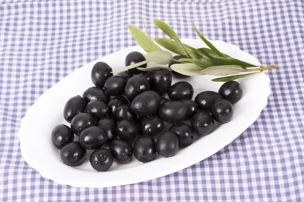 Черные оливки в белой тарелке — стоковое фото
