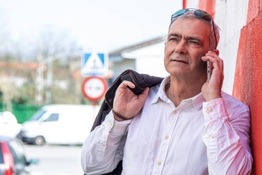 Duvarda cep telefonu kullanan bir adam.