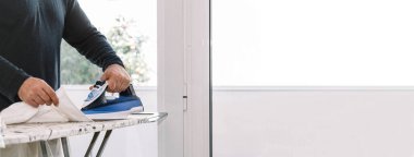 Evdeki bir gömleği fotokopi aletiyle ütüleyen adam.