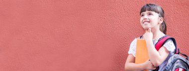 Sırt çantası ve not defteri olan öğrenci kız fotokopi alanı ile düşünüyor.