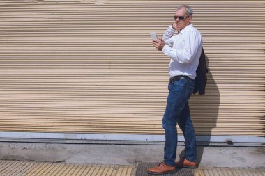 Görme engelli cep telefonu kullanan olgun bir adamın portresi