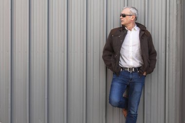 Ceketli ve gözlüklü olgun bir adam.