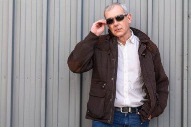 Ceketli ve gözlüklü olgun bir adam.