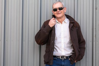 Ceketli ve gözlüklü olgun bir adam.