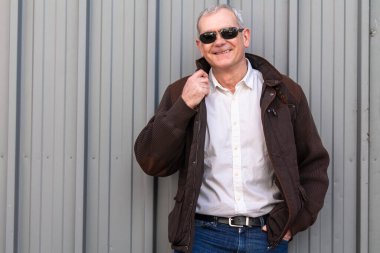 Ceketli ve gözlüklü olgun bir adam.