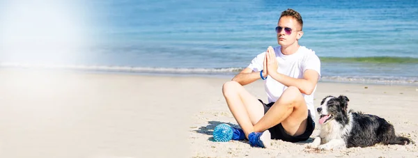 Mężczyzna Swoim Psem Plaży Ćwiczy Jogę Aby Zrelaksować Się Przestrzenią — Zdjęcie stockowe