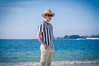 Genç adam sahilde yürüyor.