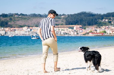 Sahilde köpeğiyle yürüyen adam