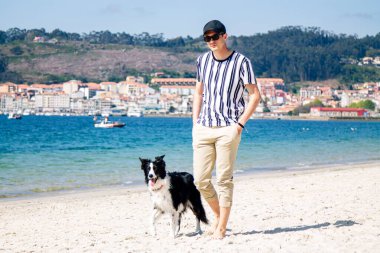 Sahilde köpeğiyle yürüyen adam