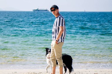 Sahilde köpeğiyle yürüyen adam