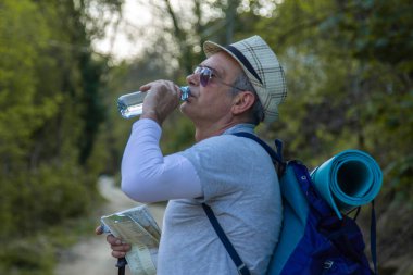 Yorgun dağcı bir içki molası verdi.