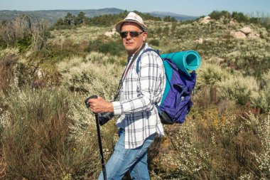 Sırt çantalı ve haritalı olgun turist dağ yürüyüşü ya da yürüyüş yapıyor.