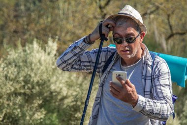 Sırt çantası ve cep telefonu olan bir gezgin.