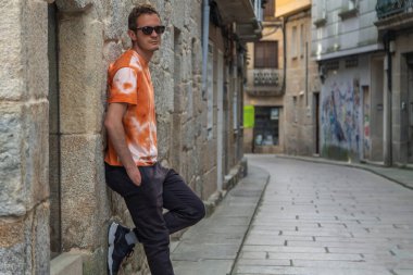 Gülümseyen turistler şehrin anıtsal bölgesinin duvarına yaslanıyorlar.