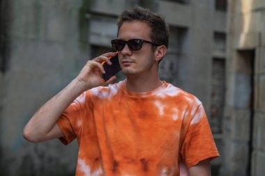 Sokaklarda cep telefonuyla konuşan genç adam.