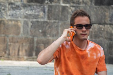 Cep telefonu anıtsal sokaklarda gezen genç bir turist.