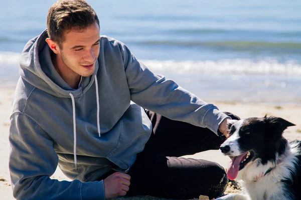 Plajda köpeğiyle genç bir adamın portresi.