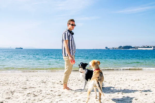 Νεαρός Άνδρας Παίζει Σκυλί Και Μπάλα Στην Παραλία — Φωτογραφία Αρχείου