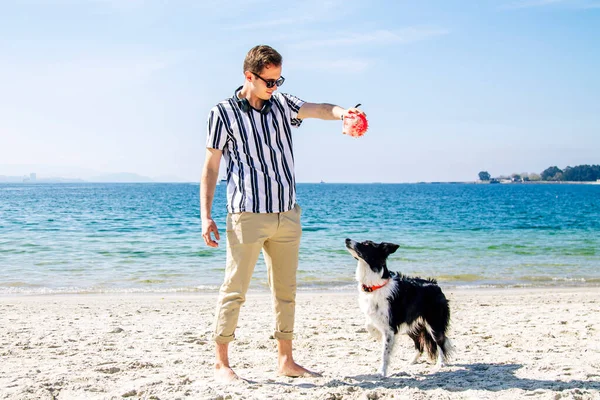 Νεαρός Άνδρας Παίζει Σκυλί Και Μπάλα Στην Παραλία — Φωτογραφία Αρχείου