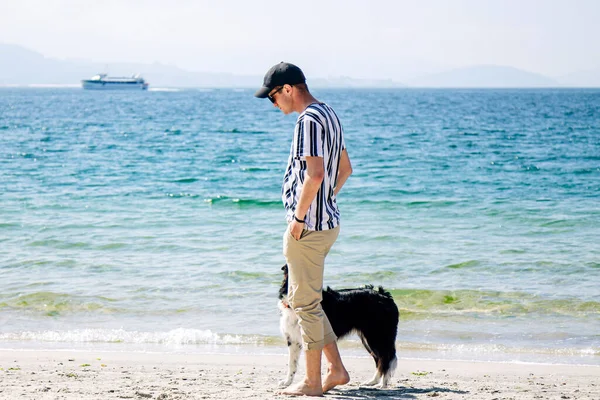 男子在海滩上与他的狗走在一起 — 图库照片